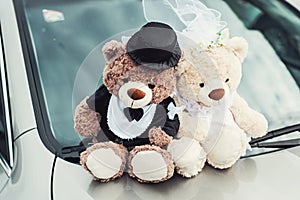 Small plush bears on a wedding. Decoration on the car hood