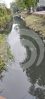 small polluted river beside the highway