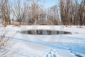 Small polynya on a small lake on a sunny day