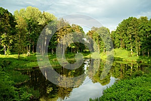 Small pond in beautiful park surrounding Uzutrakis Manor, residential manor of the Tyszkiewicz family in Uzutrakis, on the shore