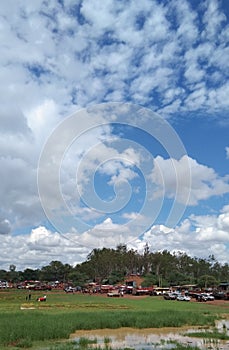 A small pond grass tree motorcycle and blue sky and white cloud