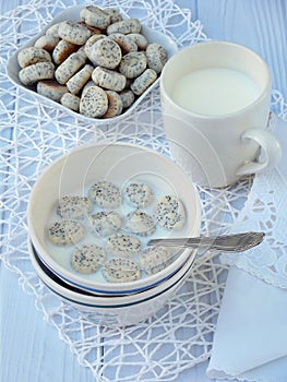 Small poppy biscuits with milk on a light background. Traditional Lithuanian Christmas cookies. Kuchykai. Sweet breakfast