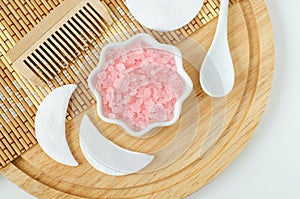 Small porcelain bowl with pink Himalayan crystal bath salt foot soak. Homemade spa and beauty treatment recipe. Flat lay, copy