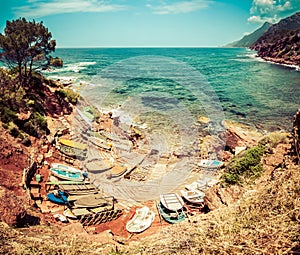 Small port with fishing boats. View to blue sea, mountains.