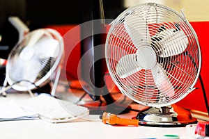 Small, portable switched off fan on desk in office