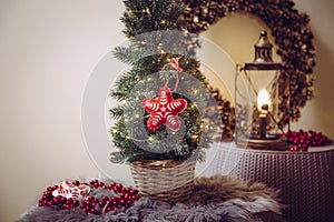 Small portable tabletop decorated Christmas tree on table  party lights illuminated  red felt fabric ornament.