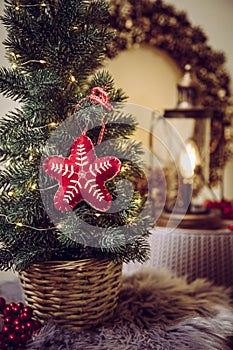 Small portable tabletop decorated Christmas tree on table  party lights illuminated  red felt fabric ornament.