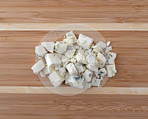 Small portion of crumbled blue cheese on a wood cutting board