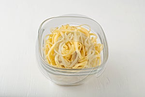 A small portion of linguini pasta in a glass
