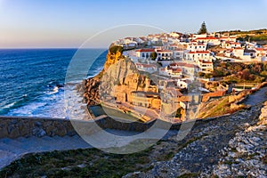 Small Portugal village Azenhas do Mar on cliff on coastline with sunset photo