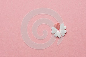 Small Pretty Flower Made of Heart Shape Sugar Candy White and Red Sprinkles on Pastel Pink Background. Valentines Mother`s Day