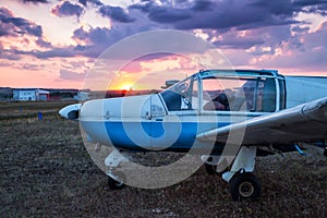 Small private airplane parked at the airfield at scenic sundown