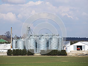 A small private farm taken from a bird`s-eye view. Video agricultural land with drone or quadrocopter. Silos, tractors and hangar