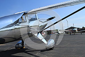 Small prop shiney metal aircraft at airport on tarmac photo