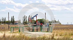 Small pump. Oil pump . Equipment for the oil industry. Oil rocking chair in the open air