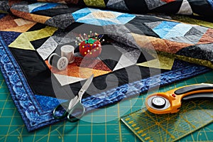 Small quilt, cutting mat and sewing and quilting accessories