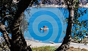 Small raft with cabin floating on California`s Lake Cachuma