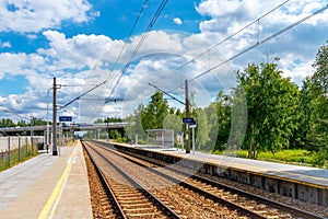 A small railway station. Car bridge in the background Railway and car transport. Sunny day