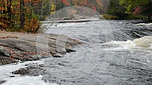 Small rapids and colorful autumn forest at Oxtongue river