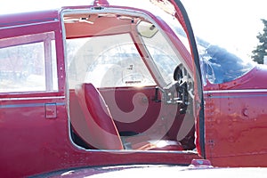 Small red airplane pilot`s cabin on a sunny day