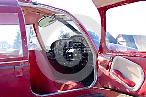 Small red airplane pilot`s cabin on a sunny day