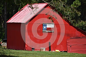 Small Red barn with corrugated painted Texas Flag