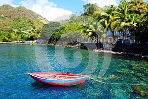 Small red boat on turquoise water