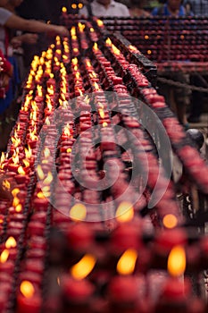 Small red candles lit by worshippers
