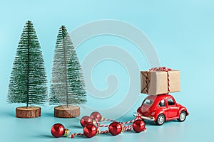 Small red car carries gift box and christmas tree with copy space. Concept Happy new year and Merry christmas. Template for design