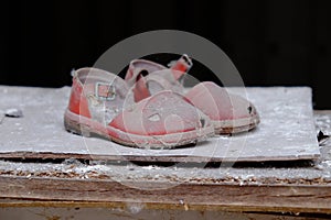 Small red children`s sandals in an abandoned kindergarten in Pripyat. Old children`s shoes