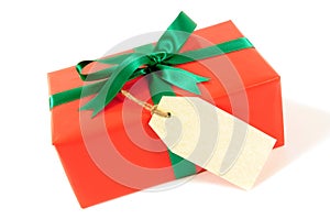 Small red christmas or birthday gift with green ribbon bow, gift tag or label, isolated on white background