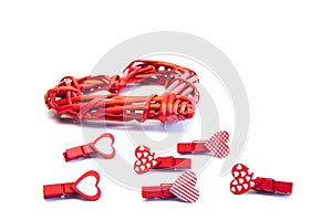 Small red clothespins hearts and a large wicker heart. On white background. Love