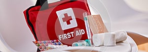 Small red First Aid kit with pills and bandages