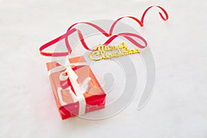 Red gift box and gold merry christmas text with red ribbon