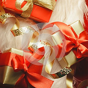 Small red and golden boxes with gifts tied bows