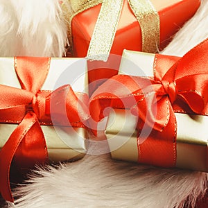 Small red and golden boxes with gifts tied bows