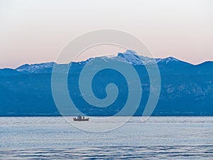 Small Red Greek Fishing Boat and Snow Capped Peloponnese Mountains, Greece