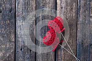 Small red hearts on a white stick on a wooden background. Love