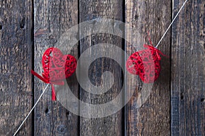 Small red hearts on a white stick on a wooden background. Love