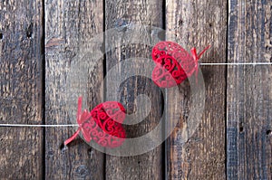 Small red hearts on a white stick on a wooden background. Love