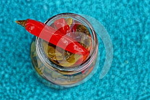 Small red canned pepper on a glass jar