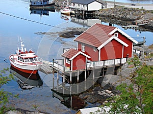 Small red house with boat in Moskenes, Lofoten photo