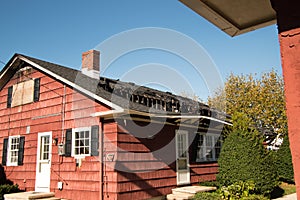 Small red house with it`s roof and top floor destroyed by fire