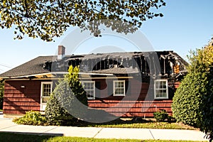 Small red house with it`s roof and top floor destroyed by fire