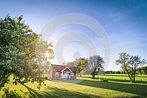 Small red house on a swedish countryside landscape