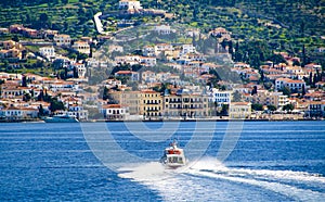 Small red motor boat transfer people to Spetses island, Greece