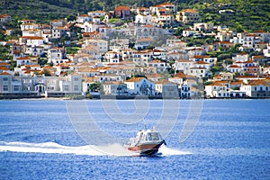 Small red motor boat transfer people to Spetses island, Greece.