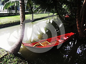 Small red paddle boat in the pond