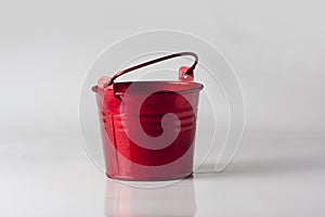 Small red decorative pail on the white background