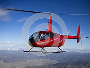 Small red rescue helicopter flying in blue sky.